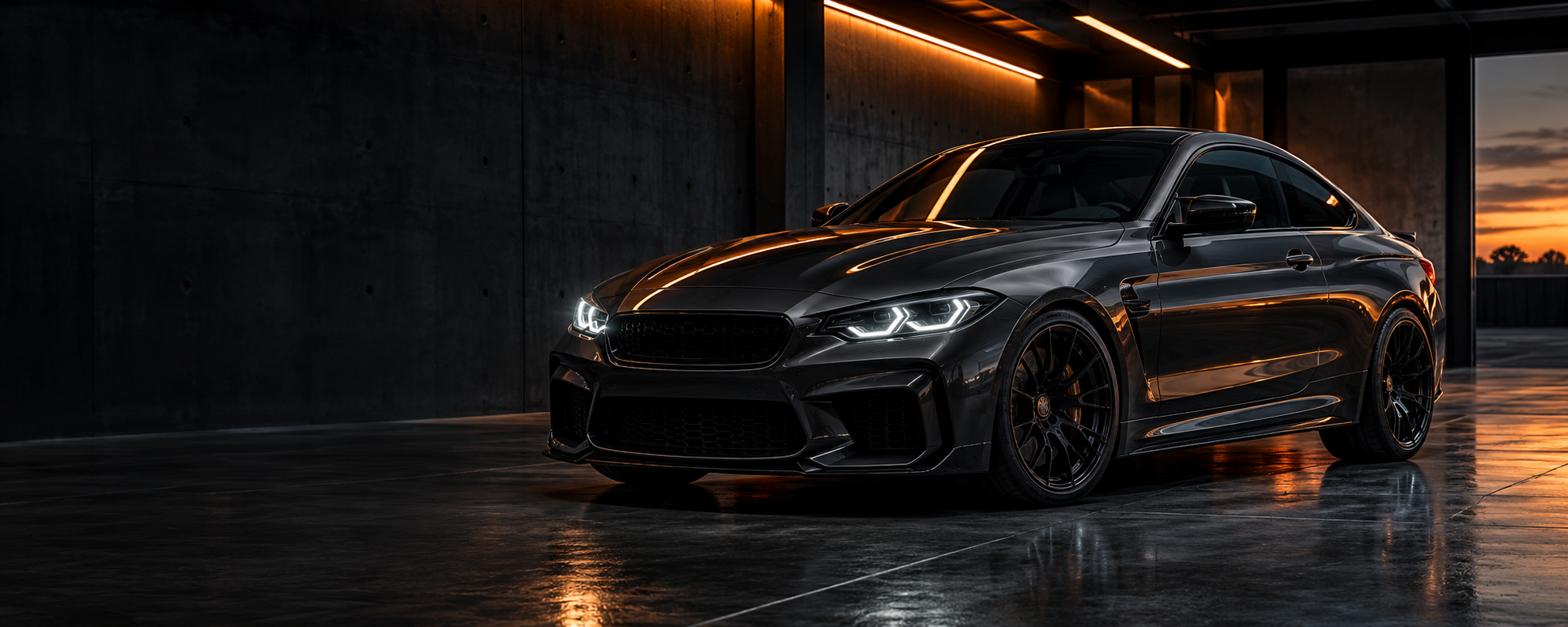 Charcoal performance coupe with warm orange reflections in a dark industrial setting